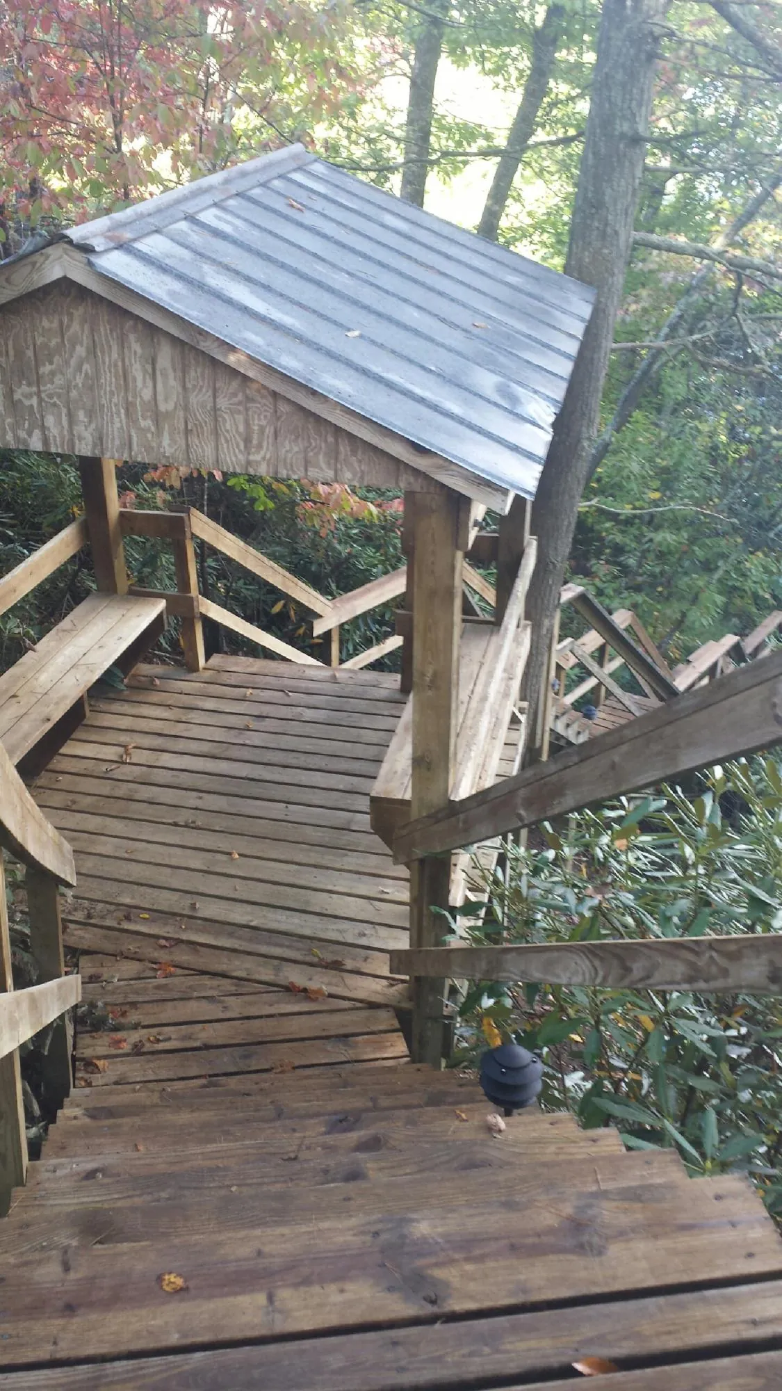 Metal roofed shelter over wooden steps on a wooded walkway — Skylight Repair & Installation work by our crew in Cumberland