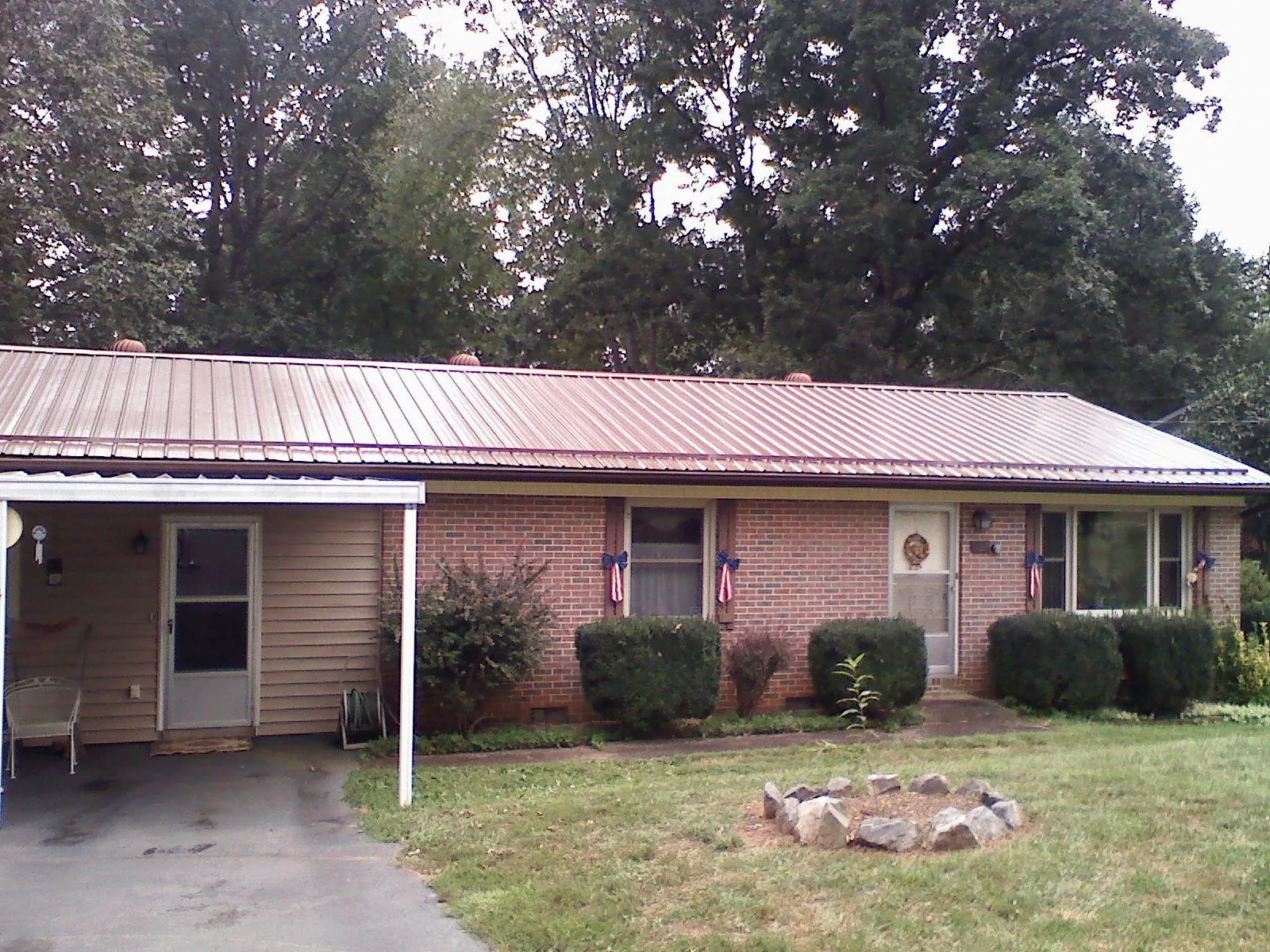 Bronze metal roof and carport on a brick ranch home — Roof Repair work by our crew in Cumberland